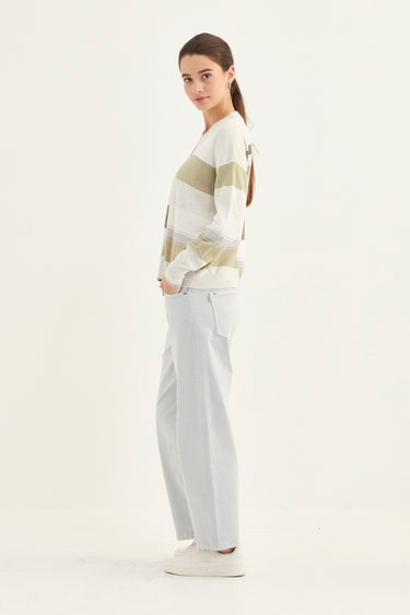 Woman wearing a striped sweater and light-colored pants by Verge on a white background