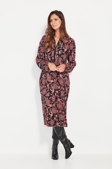 Woman wearing a floral dress by Verge with black boots on a white background