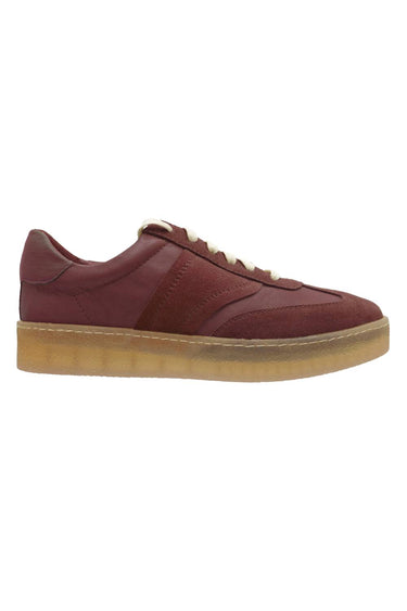 A low-top sneaker in burgundy leather with cream laces and a thick, textured gum rubber sole, shown in a side profile on a white background.