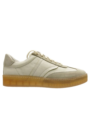A low-top sneaker in light beige leather and suede with matching beige laces and a thick, translucent gum rubber sole, shown from a side profile on a white background.