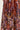 A close-up of a draped fabric by Verge with an intricate paisley and floral pattern in brown, blue, purple, gold, and cream.