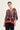 A woman modeling a loose, short-sleeved V-neck top by Verge with a multicolor paisley and floral print on the upper portion and a solid dusty rose gradient on the lower portion, paired with black pants against a plain light background.