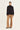 A model stands against a plain light background wearing a tan cropped zip-front jacket with long sleeves and a high collar, paired with wide-leg tan pants by Verge, against a plain light background.