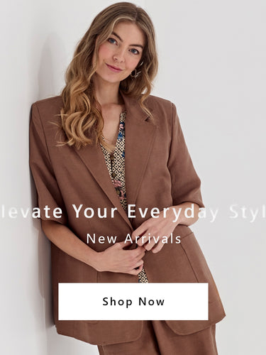 A woman wearing a brown tailored blazer by Verge over a patterned top, leaning against a light gray wall. White text overlays read 'Elevate Your Everyday Style', 'New Arrivals', and there is a 'Shop Now' button at the bottom.