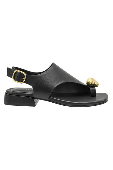 A black leather thong sandal with a low block heel, adjustable ankle strap with a gold buckle, and a gold heart-shaped embellishment on the toe strap, shown against a plain white background.