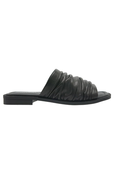 A single black leather slide sandal with a ruched, pleated strap and a low block heel, shown in profile against a plain white background. A Verge selection.