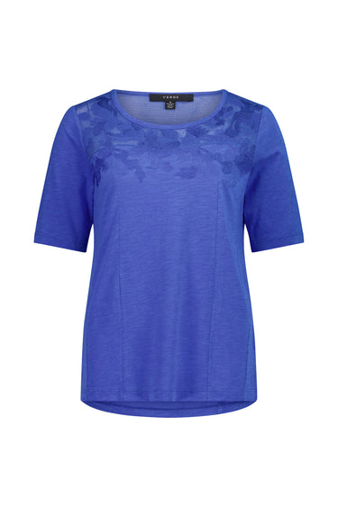 A royal blue short-sleeve top by Verge with a sheer floral lace overlay across the chest, displayed on a clean white background.