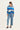 Woman wearing a blue and gray striped sweater and light blue jeans by Verge on a white background