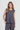 A woman modeling a sleeveless dark gray textured top and matching pants by Verge against a light gray studio background.