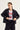 A woman modeling a black cropped blazer over a white graphic T-shirt with red cherry artwork and text, paired with black pants by Verge, against a plain light background.