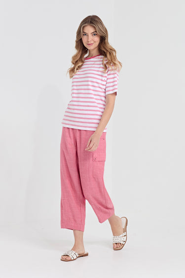 A woman modeling a pink and white striped short-sleeve t-shirt and matching pink cropped pants by Verge, paired with white slide sandals, against a plain white studio background.