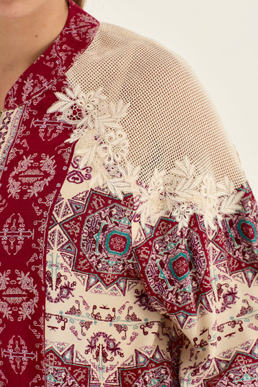 Close-up of a patterned kurta featuring a cream mesh upper section with white floral lace applique, a deep red collar with white embroidery, and a multicolor geometric print by Verge on the lower body.