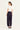 Woman wearing a white top and Midnight Homeland Pants by Verge on a white background