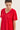 Close-up of a model wearing a red short-sleeve top by Verge with black lace applique panels along the shoulder and side, against a plain light background.