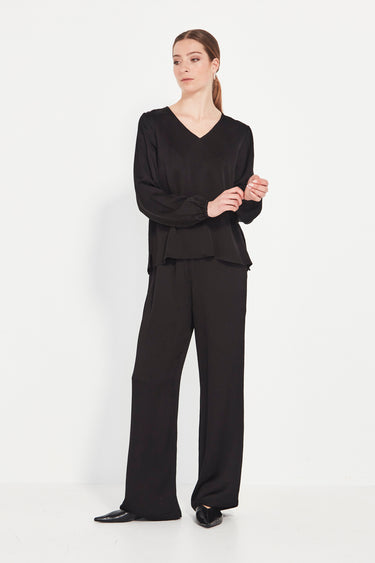 Woman wearing a black outfit by Verge on a white background