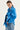 A woman wearing a bright blue lightweight jacket and light-wash blue jeans by Verge, photographed against a plain light background.