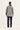 A person shown from the back wearing a light gray utility jacket and dark navy pants by Verge, against a plain white studio background.