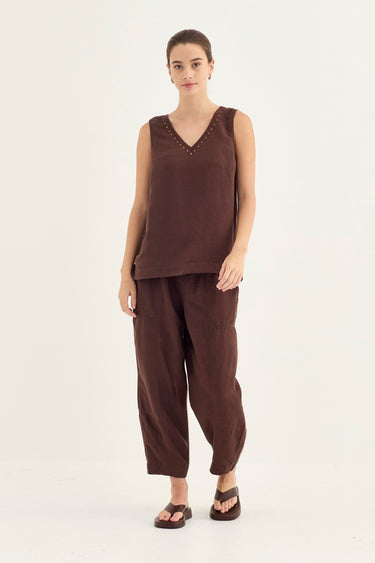 A woman modeling a dark brown sleeveless tank and matching wide-leg pants set by Verge, paired with dark brown sandals, against a plain white studio background.